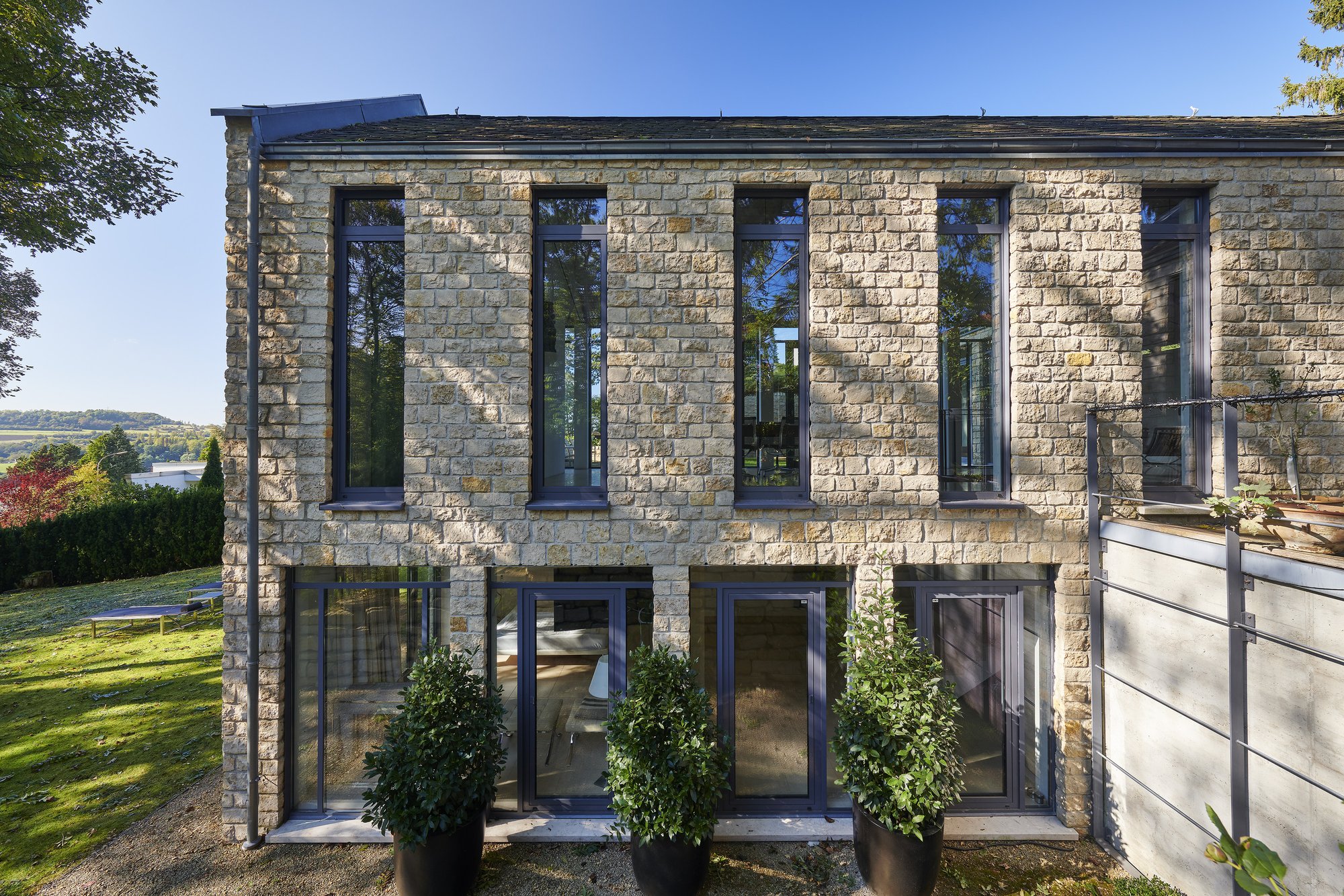 Architekturfotografie Haus S., Bliesgau — Die zweigeschossige Pfeilerfassade mit schmalen Stahlfenstern