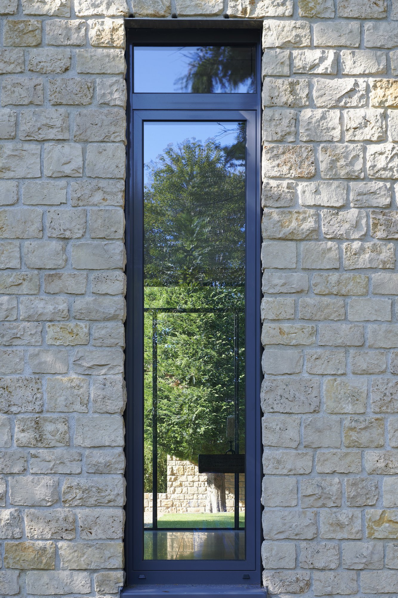 Architekturfotografie Haus S., Bliesgau — Detail: hohes Stahlfenster im Kalksteinmauerwerk