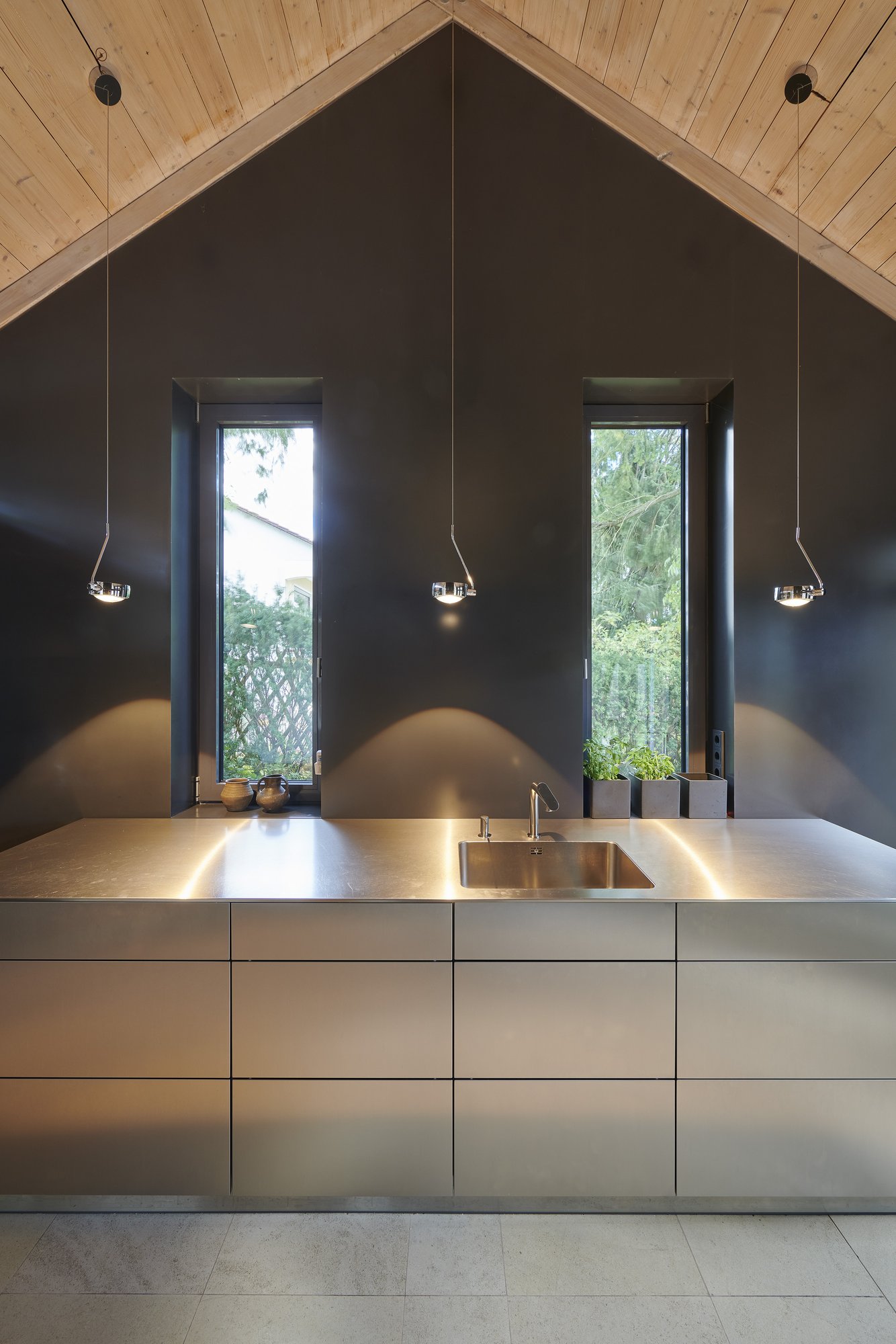 Architekturfotografie Haus S., Bliesgau — Küche mit Kochinsel aus Edelstahl unter dem Satteldach