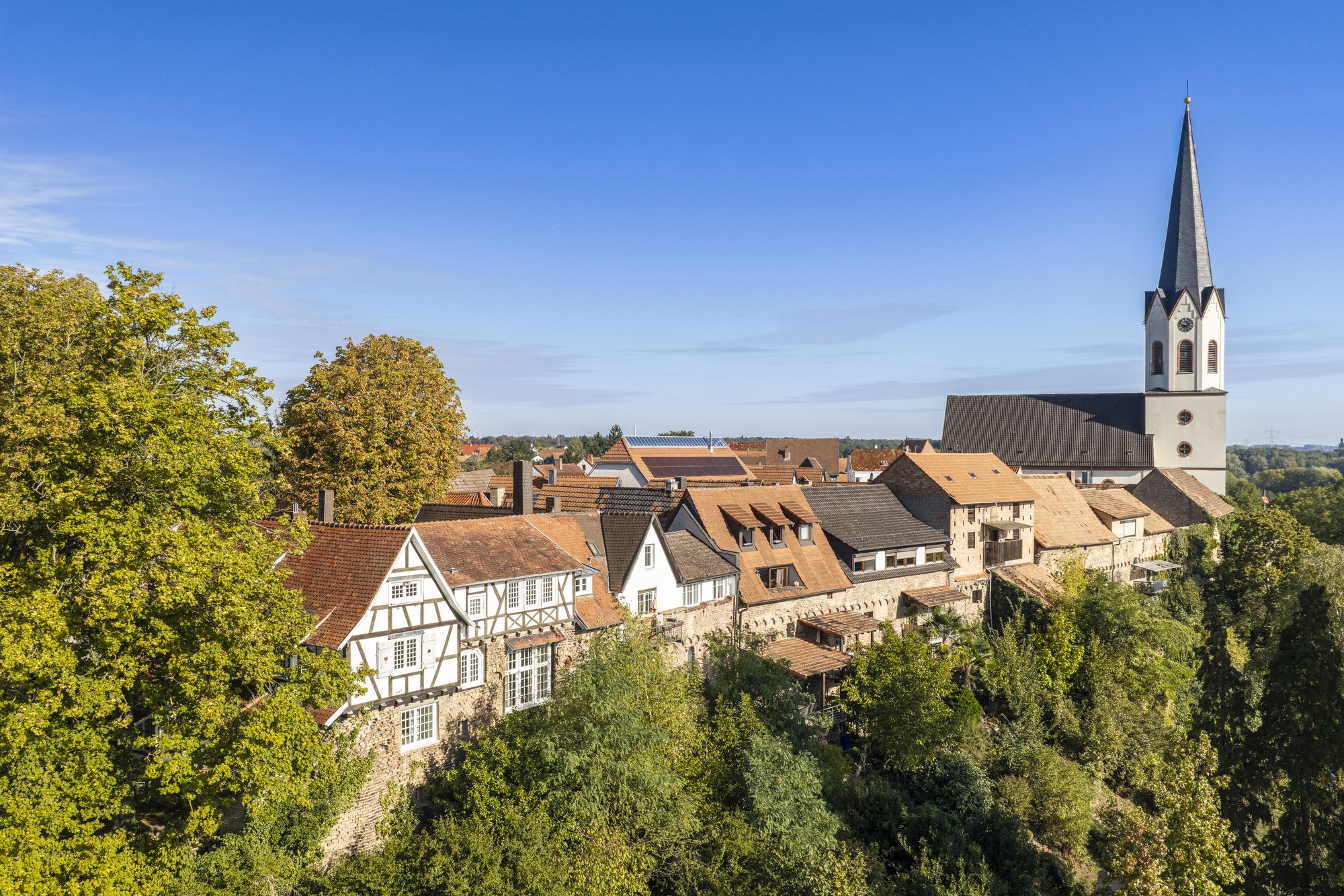 Jockgrim — Fachwerkhäuser des Hinnerstädels an der Geländekante, dahinter der Turm der Pfarrkirche St. Dionysius