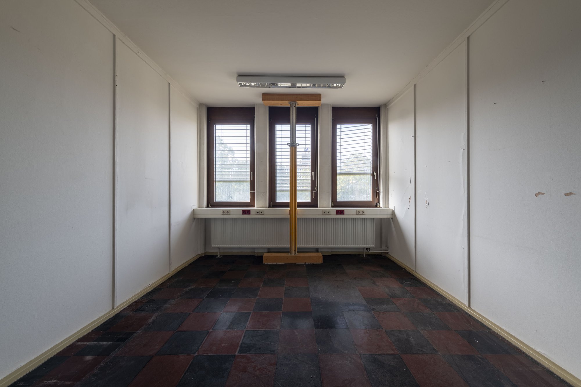 Architekturfotografie ehemalige Französische Botschaft, Saarbrücken — Leergeräumtes Büro mit drei Fenstern und gelben Baustempeln