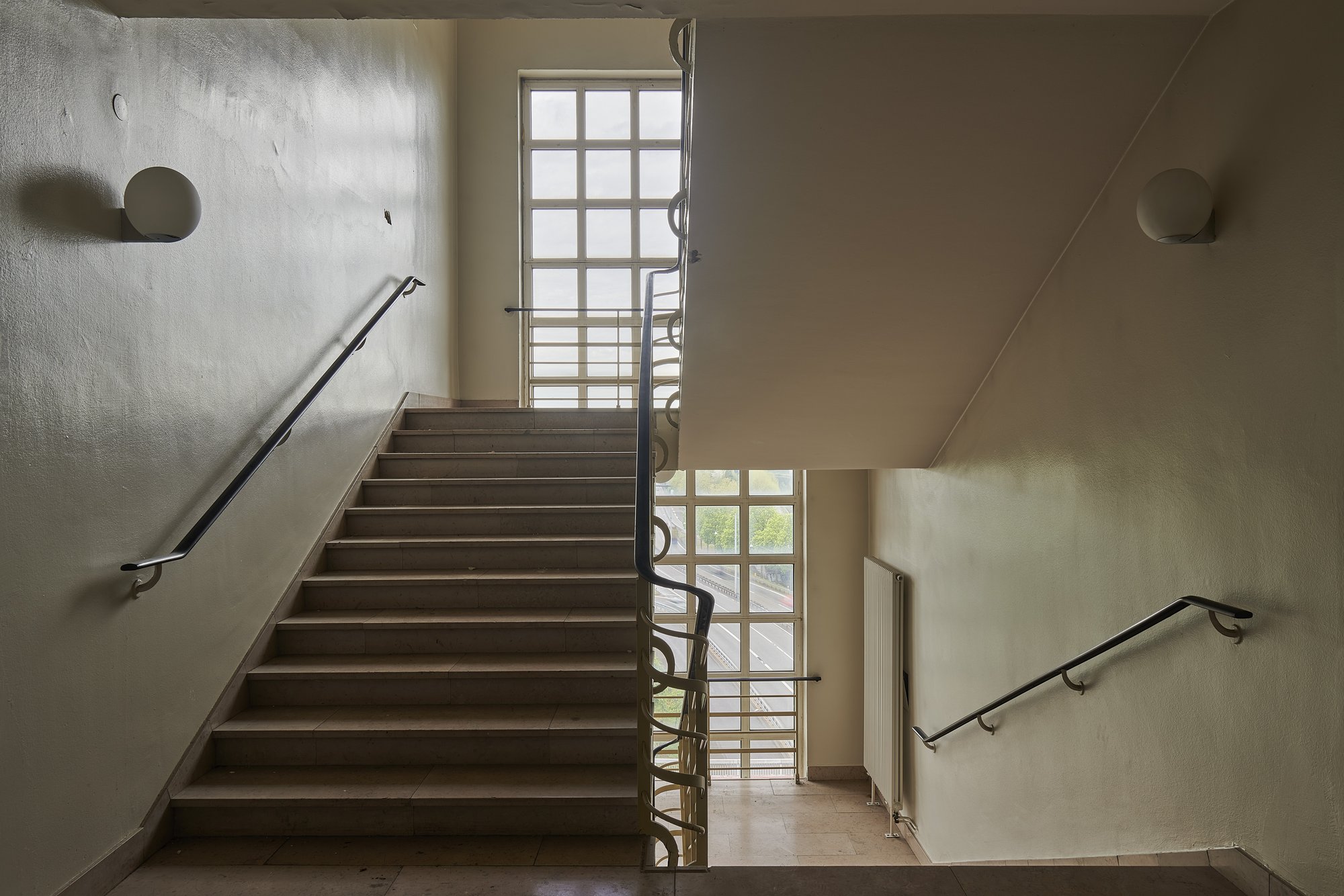 Architekturfotografie ehemalige Französische Botschaft, Saarbrücken — Treppenhaus mit Glasbausteinfenster und schmiedeeisernem Geländer