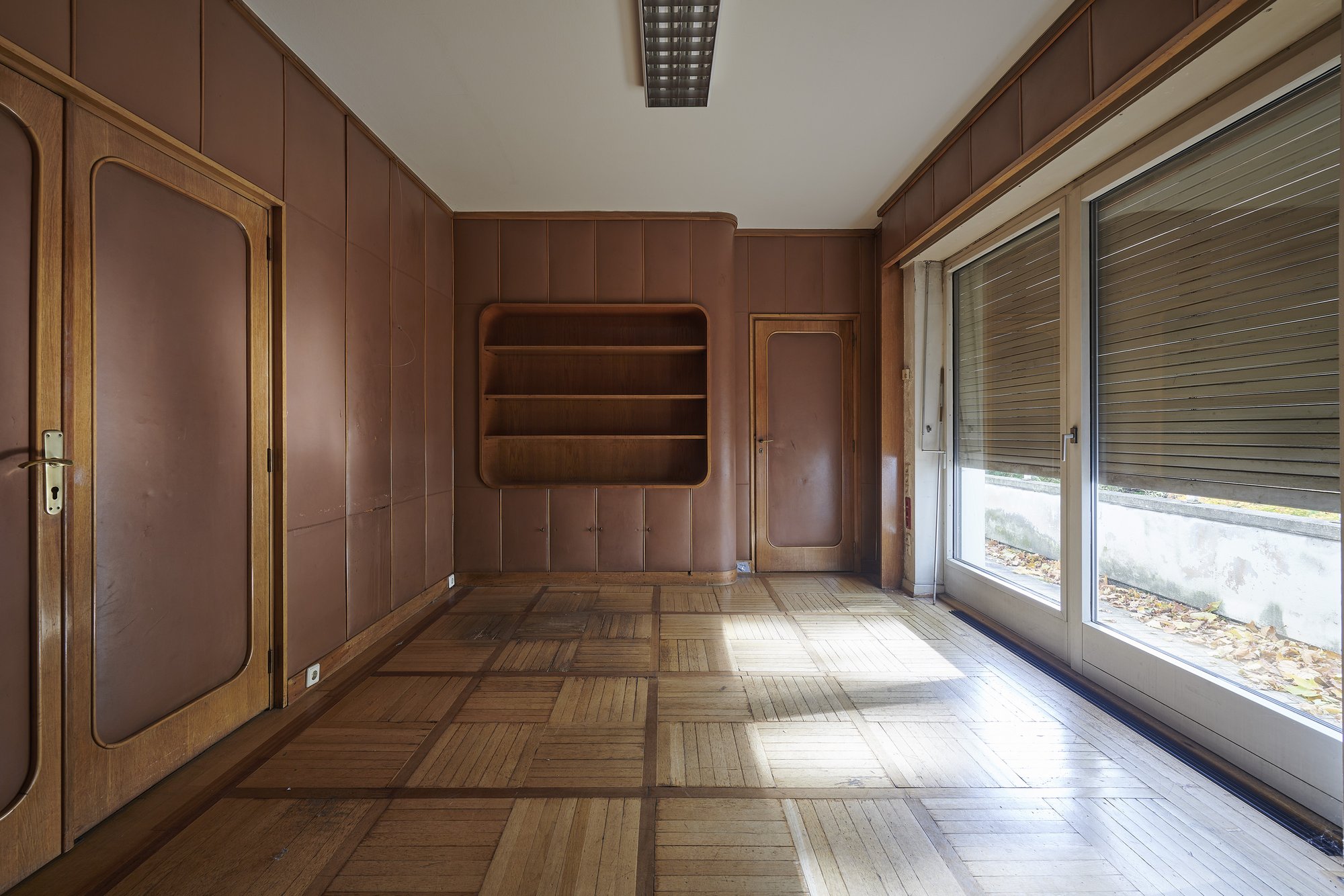 Architekturfotografie ehemalige Französische Botschaft, Saarbrücken — Zimmer mit brauner Wandbespannung, Einbauregal und Fensterfront